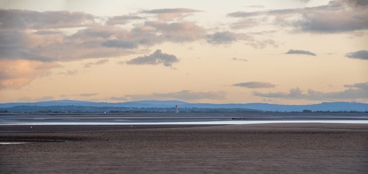 Clouds float over the mountain ranges of Snowdonia seen from Liverpool bay.