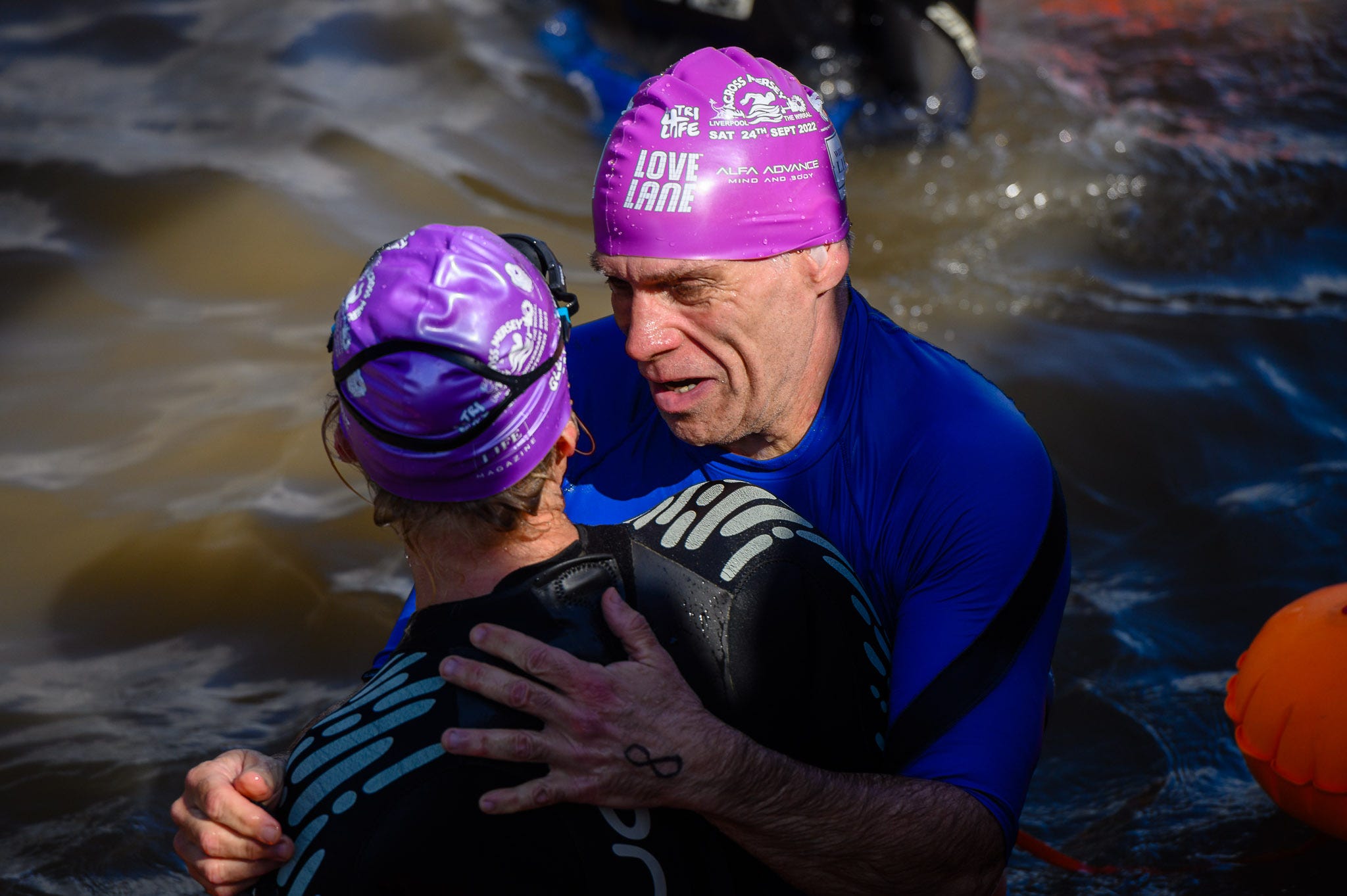 Two people embrace after finishing a 2 mile swim.