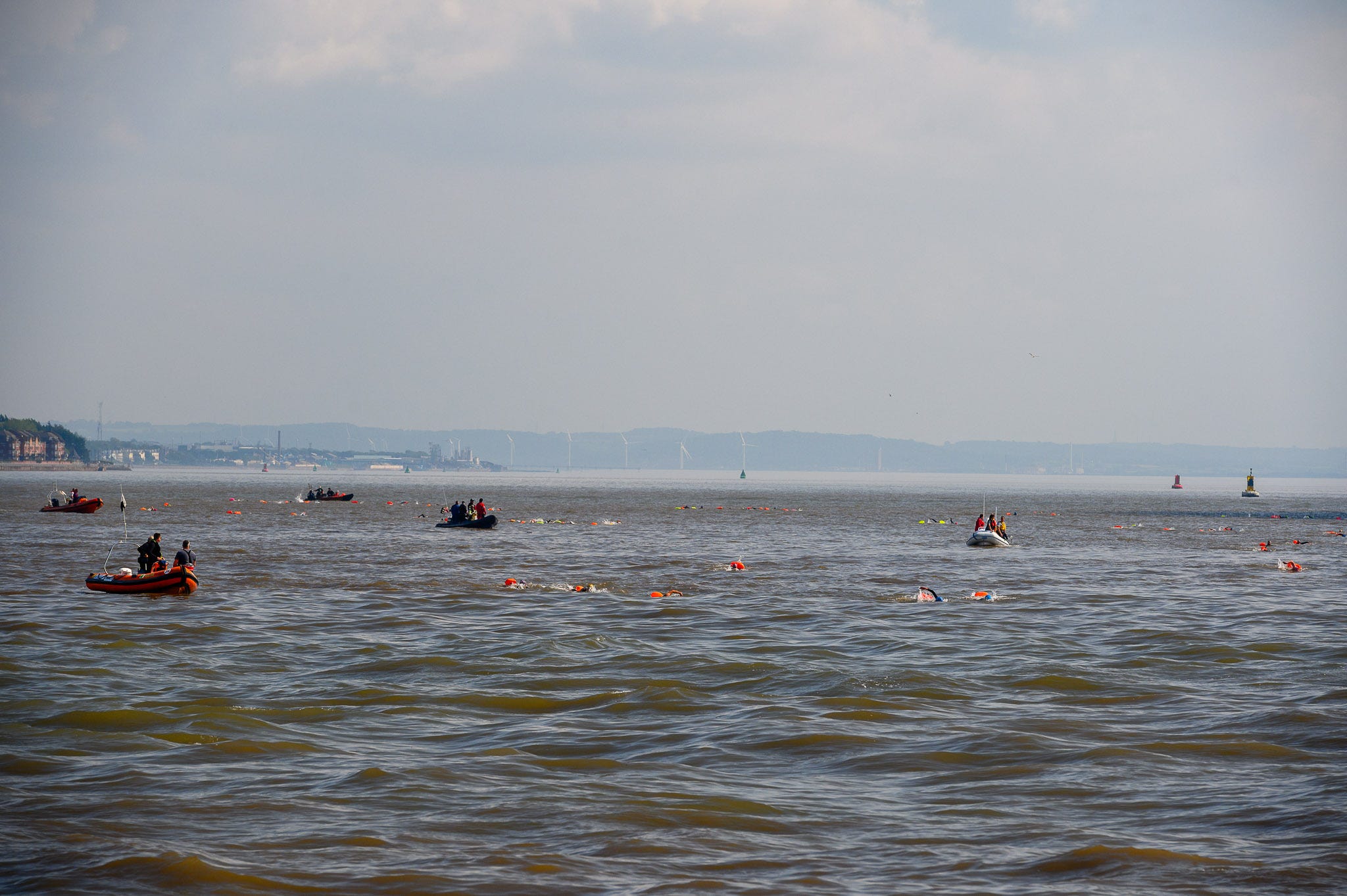 Orange dots in the water are toe floats from swimmers. There are hills way off in the distance.