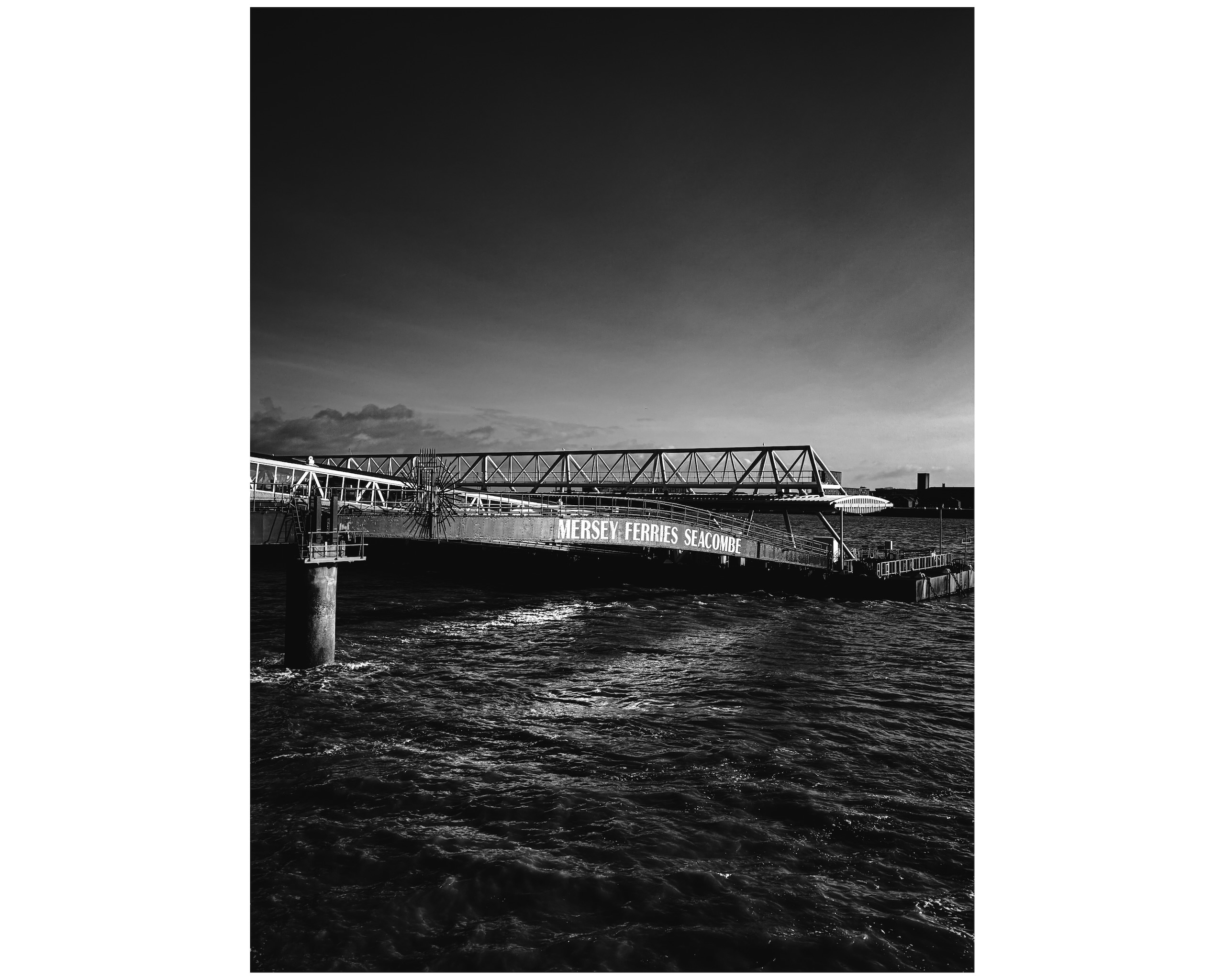 Mersey Ferries Seacombe linkspan bridge at high tide in black and white.