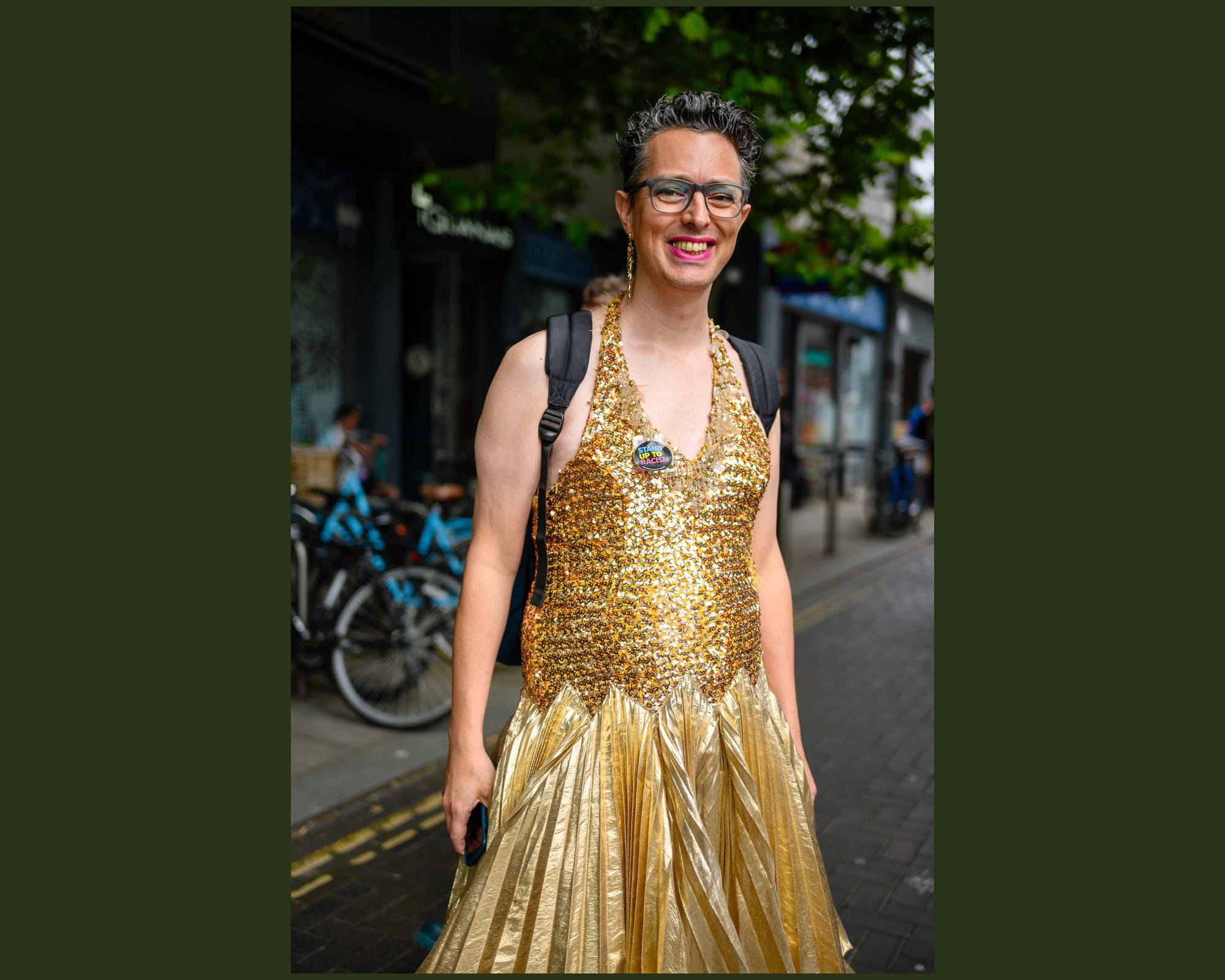 A person wears a stunning gold sequin dress and red lipstick.