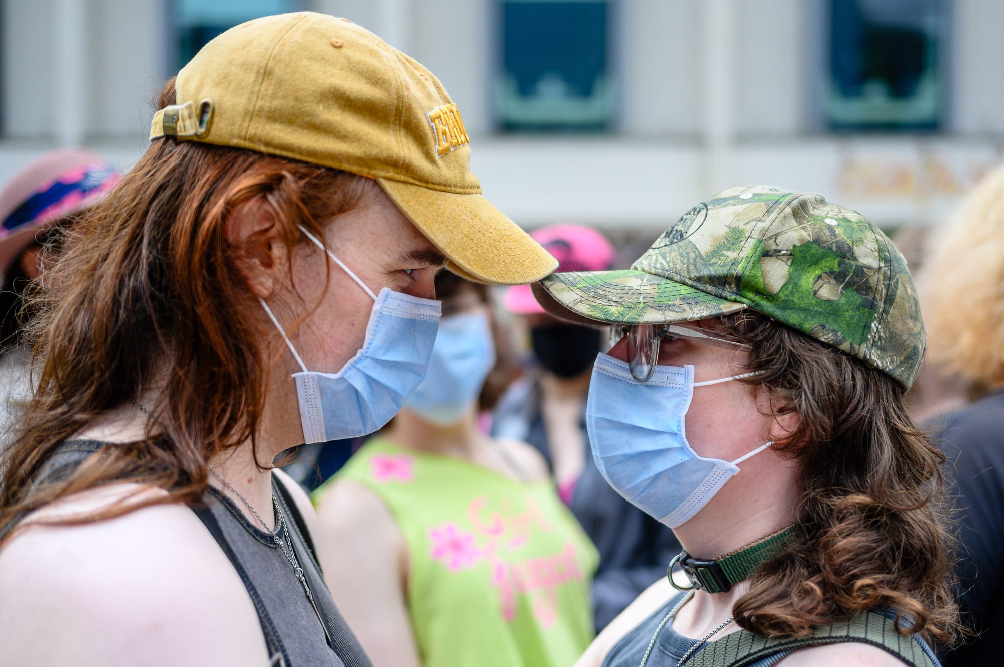 Two people wearing masks stare into each other’s eyes.