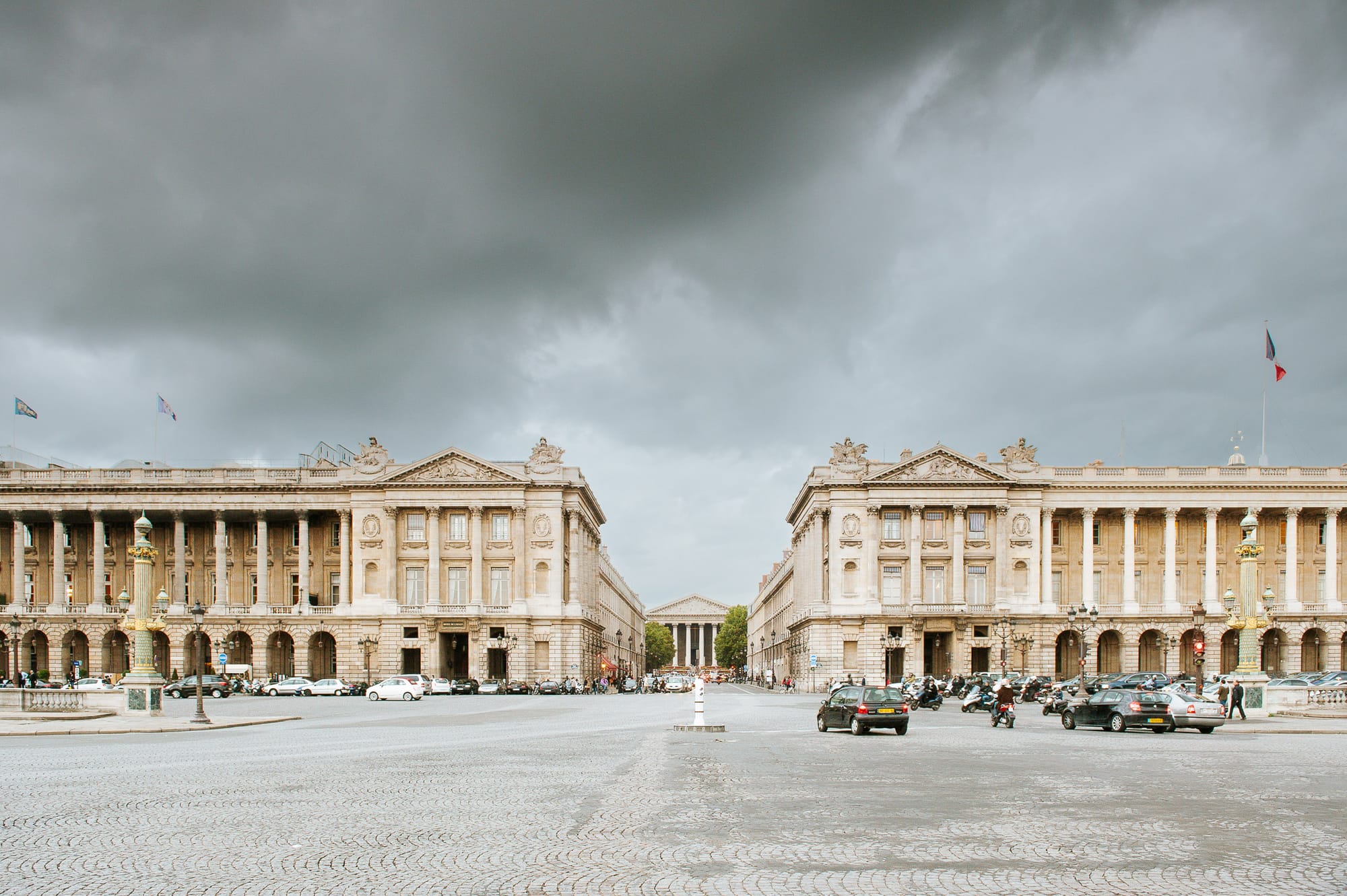 Grand Parisian architecture of the Hotel de Coislin with passing cars on an overcast day.