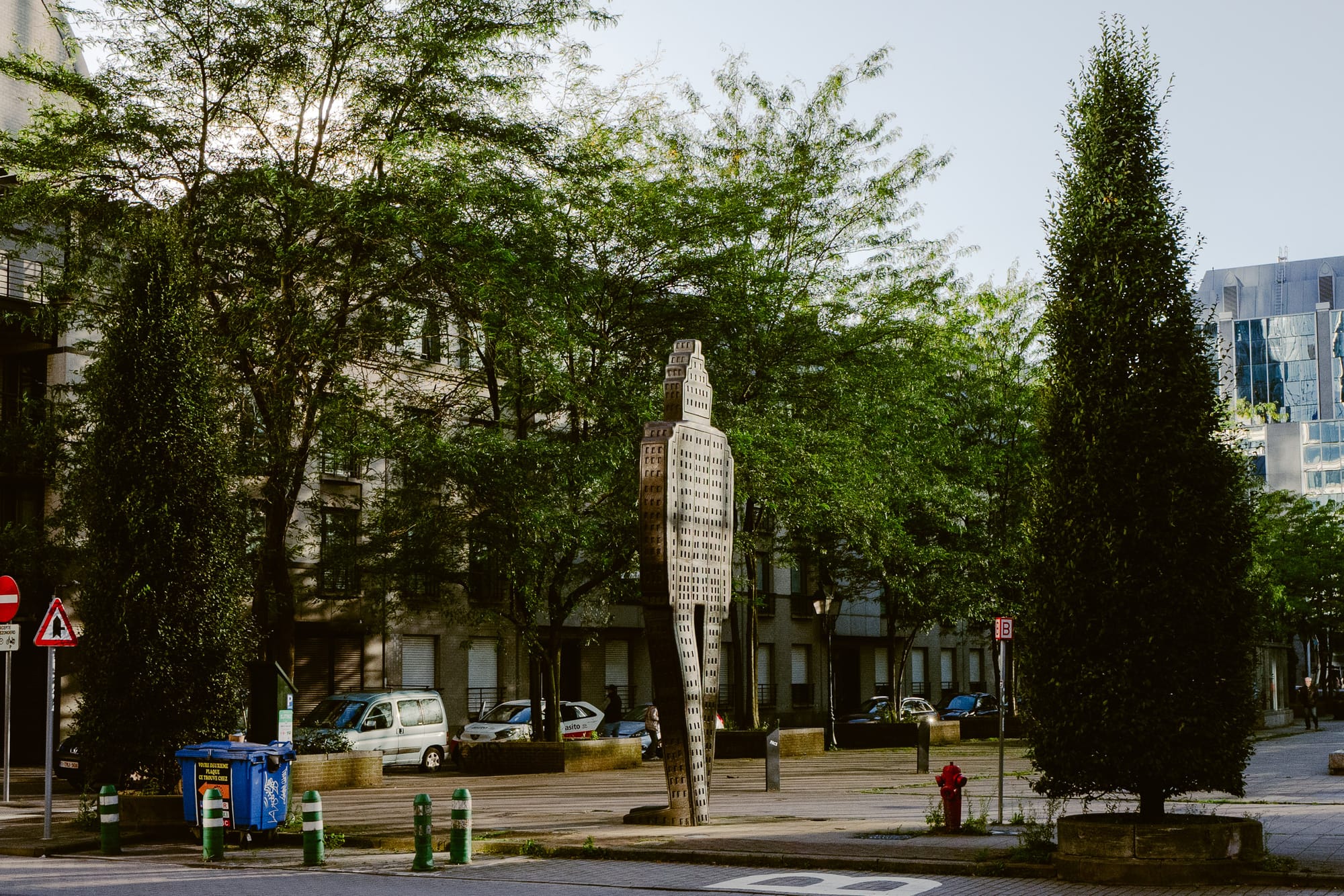 A metal figure of a robot stands about 3 meters tall not far from some apartments.