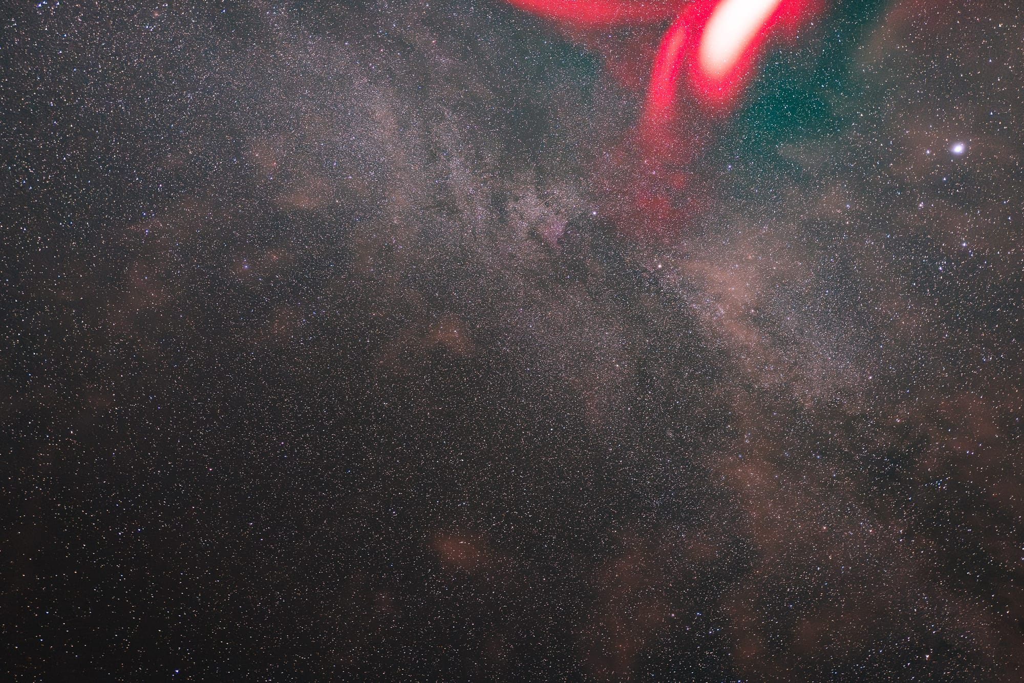 Night sky with stars and a red glow.