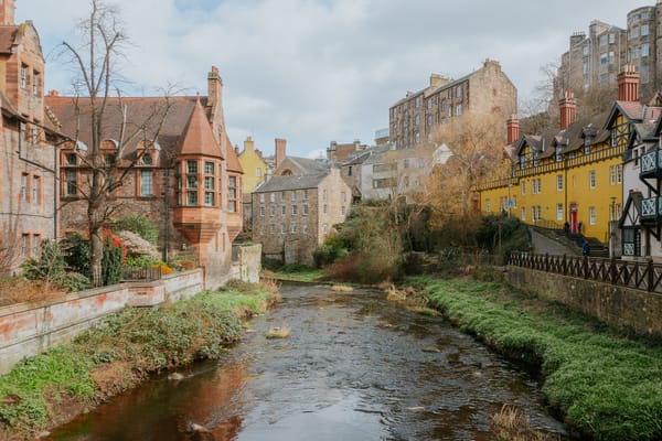 A beautiful collection of old victorian red brick buildings with a river running through the scene.