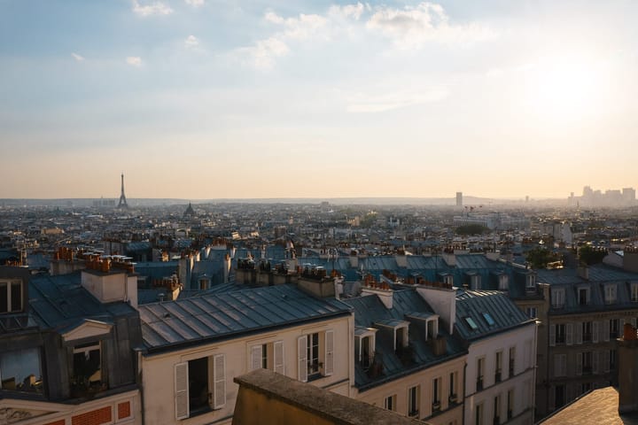 The Eiffel Tower stands tall above the rooftop skyline of Paris.