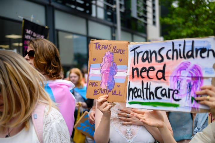 A sign says "Trans people are beautiful"