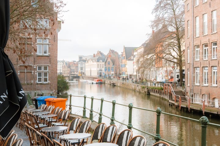 A canal scene in Gent, featuring brick buildings lining the waterway. 