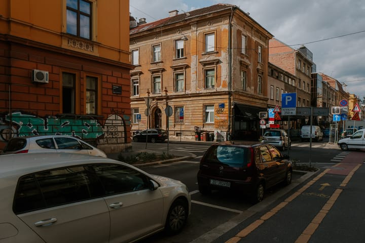 A street in Zagreb, Croatia. Most buildings are three stories high and painted yellow / orange.