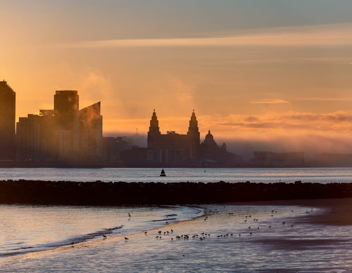 Standing across the River Mersey with the tide out and fog rolling in around the city of Liverpool.