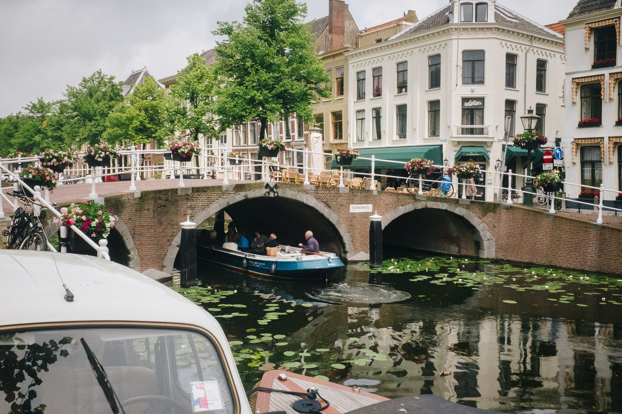Boats travelling along a canal in Leiden during summer.