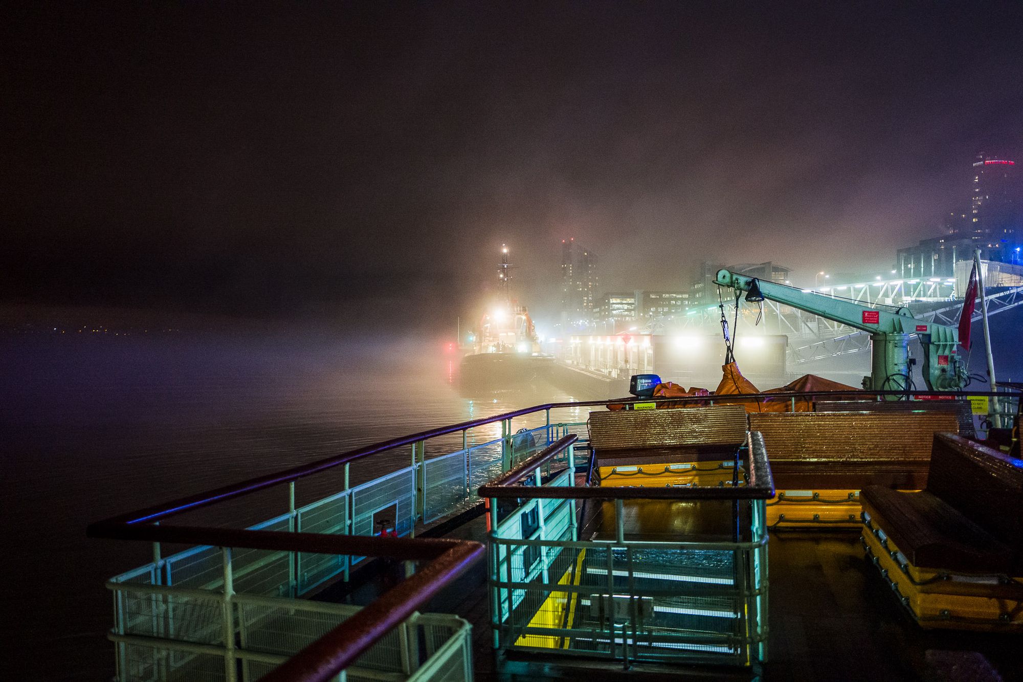 Fog moving over a docked tug boat viewed from the back of a Mersey Ferry.