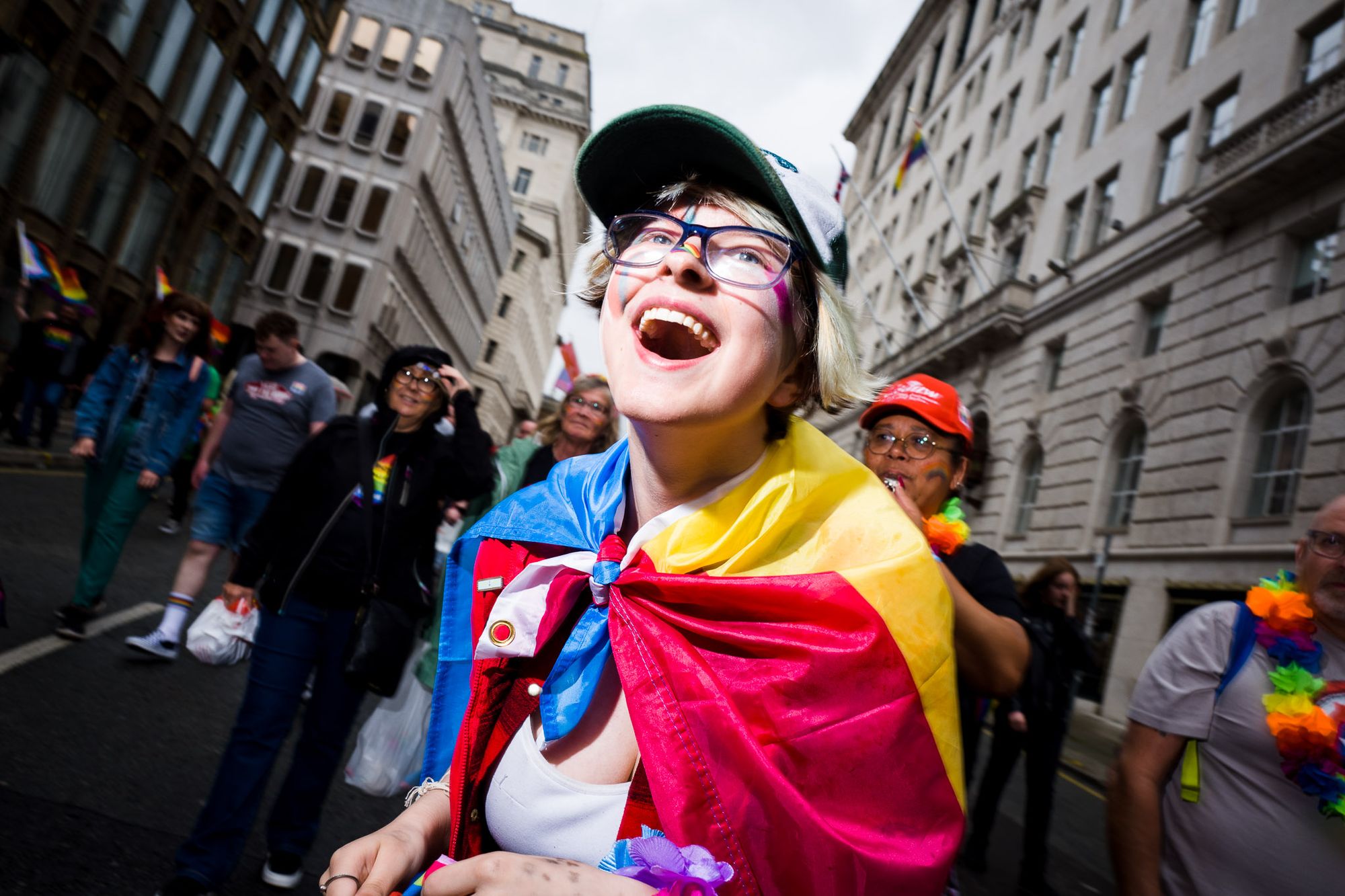 A happy person at pride wearing a pansexual flag.