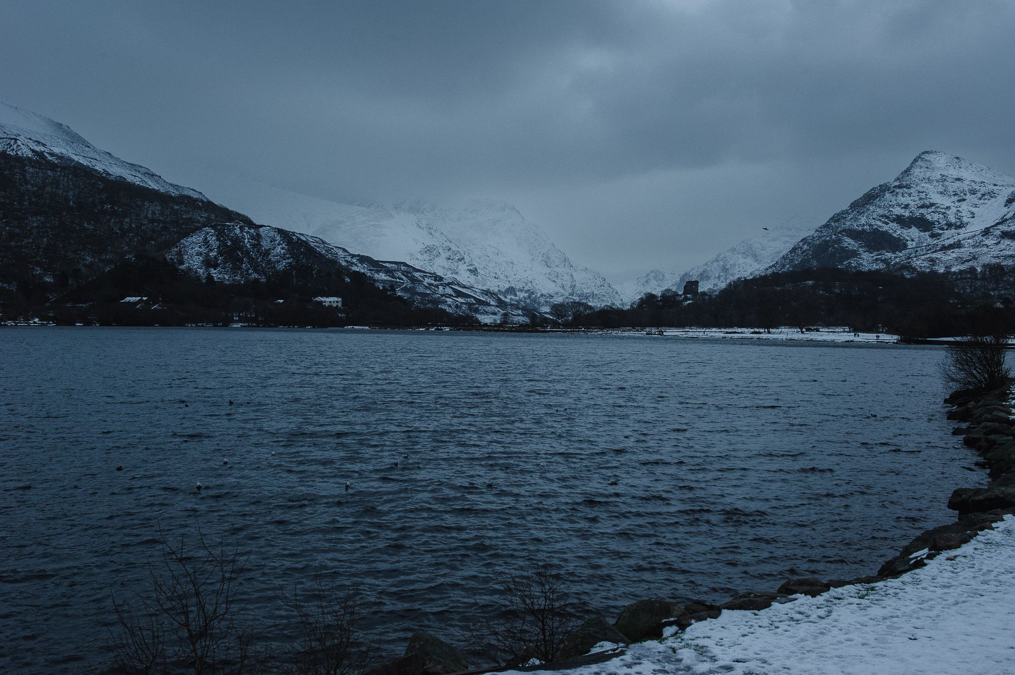Dusk light falls over Lake Pardarn with Snowdonian mountains behind.