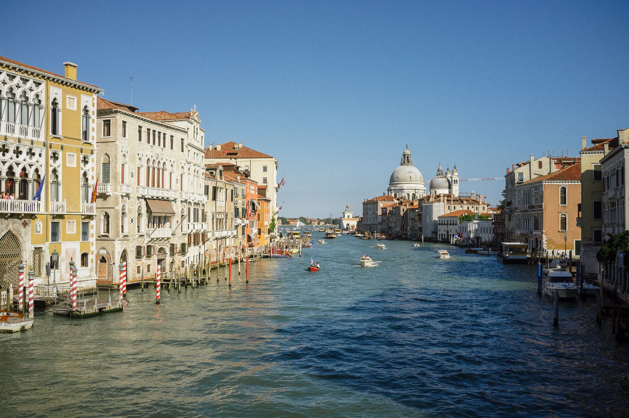 A view down the grand canal in Venice towards a cathedral.