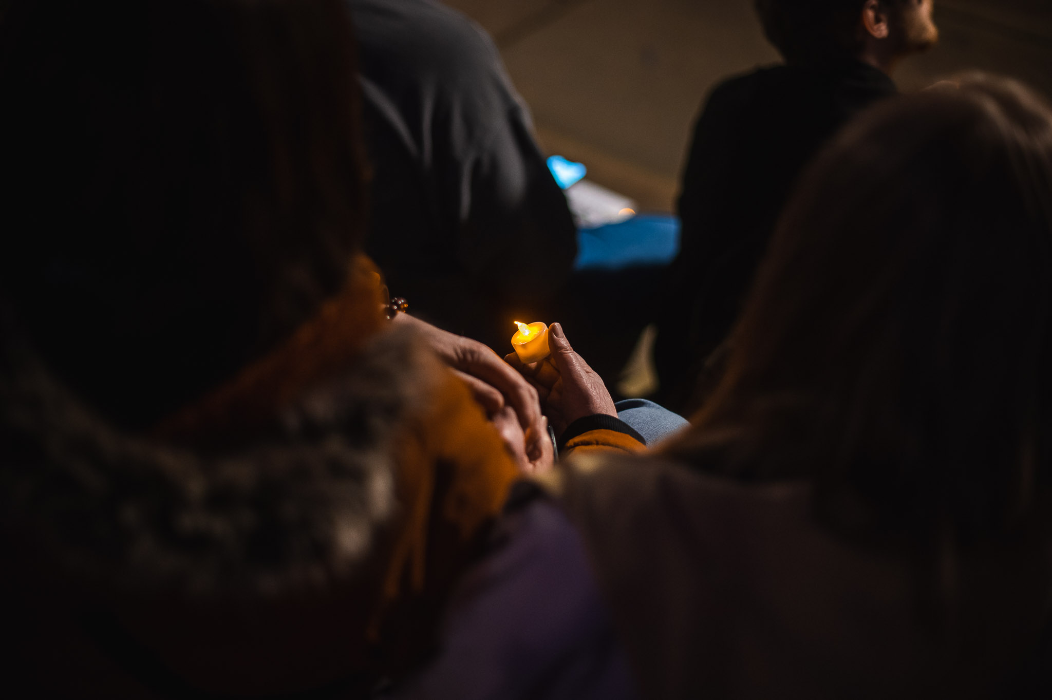 A person holds a single candle at a vigil.